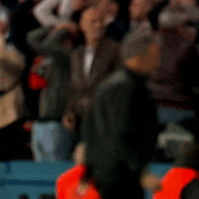 a man is standing in front of a crowd of people .