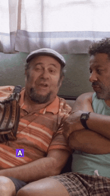 two men are sitting next to each other with the letter a on the bottom