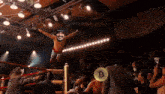 a wrestler is flying through the air in a boxing ring