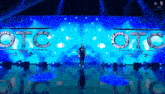 a man is standing in front of a stage that says otc on it