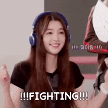 a girl wearing headphones is smiling and says fighting !!!