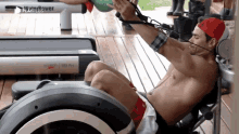a shirtless man is doing exercises on a machine that says water rower on it