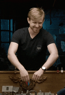a man wearing a black t-shirt with the letters rh on it