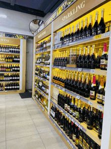 bottles of sparkling wine are lined up on a store shelf