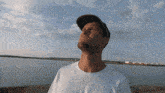 a man in a hat looks up at the sky