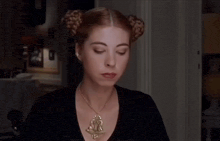 a woman wearing a necklace with a lion on it is holding a fork in her mouth