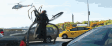 a helicopter with the word chrysler on the side is flying over a busy street