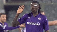 a man in a purple shirt with mediacom on the front