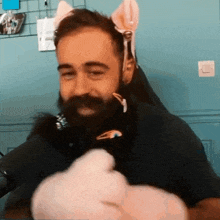 a man with a beard is wearing a cat ear headband