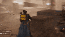 a man in a blue cape with a yellow square on his back is in a video game