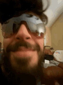 a man with a beard wearing sunglasses is smiling for the camera