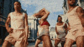 a group of men and women are dancing on a street in front of a sign that says broadway