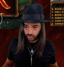 a man with long hair wearing a fedora and a necklace with an eye on it