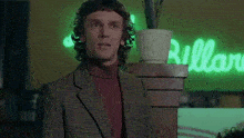 a man in a suit stands in front of a green sign that says billard
