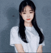 a young woman with long black hair wearing a white shirt