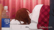 a woman laying on a bed next to a bottle of poketon
