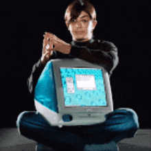 a person is sitting on the floor holding a computer