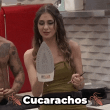a woman in a green dress is holding an iron with the word cucarachos above her