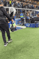 a man holding a camera on a soccer field has the number 97 on his shirt
