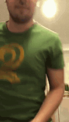 a man in a green t-shirt with a yellow circle on it