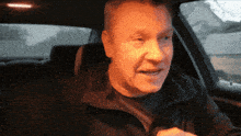 a man sitting in a car with his mouth open