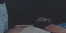 a person is laying on a bed with their legs crossed and their hands on their knees .