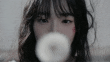 a close up of a woman blowing a bubble