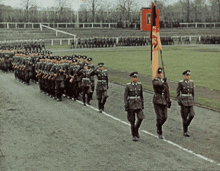 a group of soldiers marching in a parade with a flag that says ' a ' on it