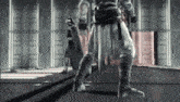 a man in a costume is standing in a room with a gun .