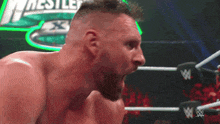 a man in a wrestling ring with his mouth open and a wwe logo in the background