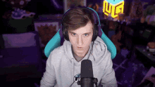 a young man wearing headphones is sitting in front of a microphone and a sign that says ig