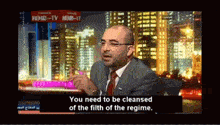 a man in a suit and tie is talking on a tv show