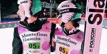 two skiers wearing shirts that say montefiore einstein and polycom