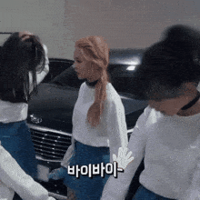 a woman in a white sweater and blue skirt stands next to another woman in a white sweater