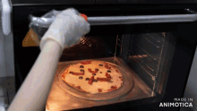 a person is putting a pizza in an oven with the words made in animatica on the bottom