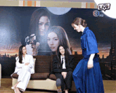 three women are sitting on a couch in front of a wall that says 3plus live on it