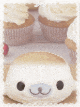 cupcakes with frosting and a stuffed animal in the background