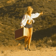 a woman with a suitcase is giving a thumbs up sign