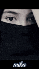 a close up of a woman wearing a black hijab with the name mika on the bottom