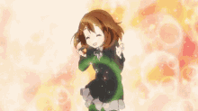 a girl in a school uniform is dancing with a green ribbon around her neck .