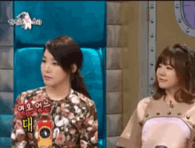 two women sitting next to each other with one wearing a shirt that says ' ao ' on it