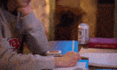 a person sitting at a table with a can of rite on the table