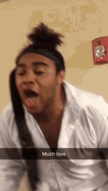 a man wearing a white shirt and tie is making a funny face with the words much love below him
