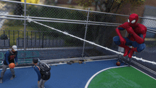 a man in a number 23 jersey stands on a basketball court next to a spiderman