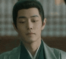 a young man with his eyes closed is wearing a kimono .