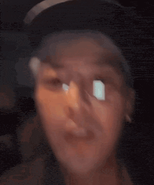 a close up of a person 's face with glasses and a hat