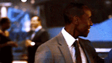 a man in a suit and tie stands in a crowd