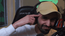 a man wearing headphones and a hat with dxr on it