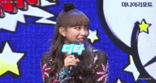 a woman is holding a microphone with a sign that says cielo on it