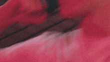 a close up of a person laying on a bed with a pink blanket on it .